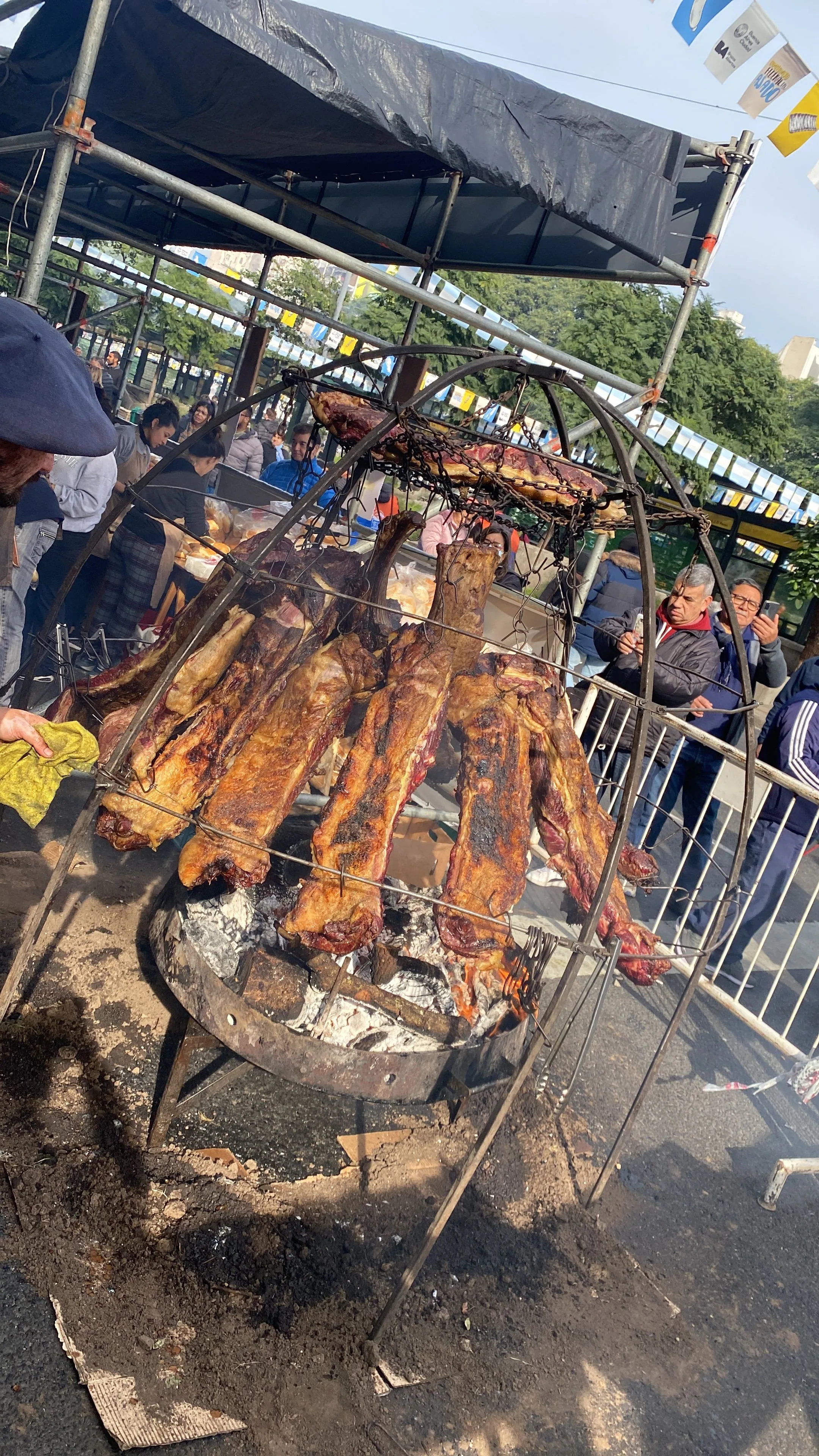 Racks of ribs roasting on a large iron cross in front of the guests