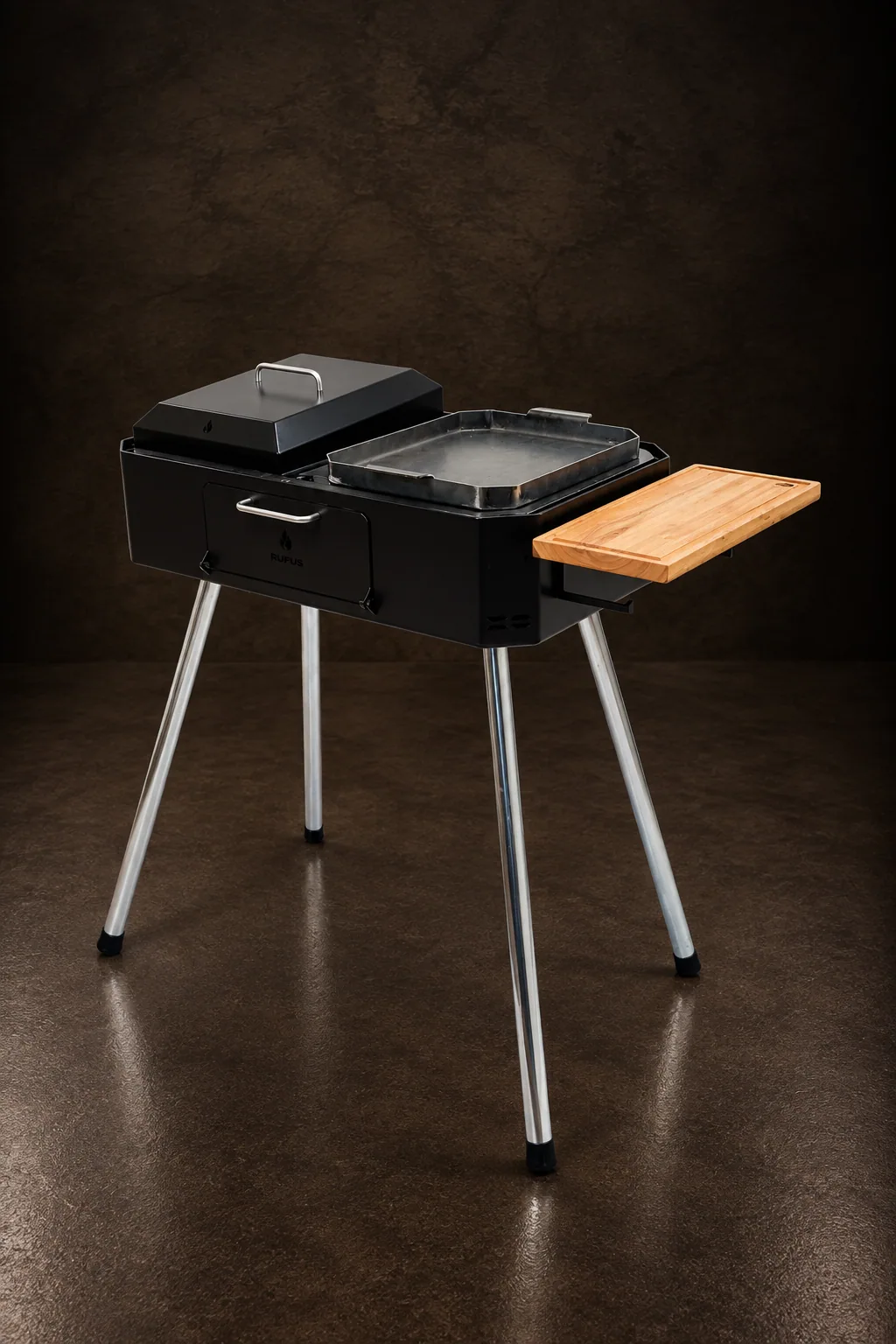 La parrilla a carbón Austral 75 sobre sus patas cincadas, sobre piedra oscura
