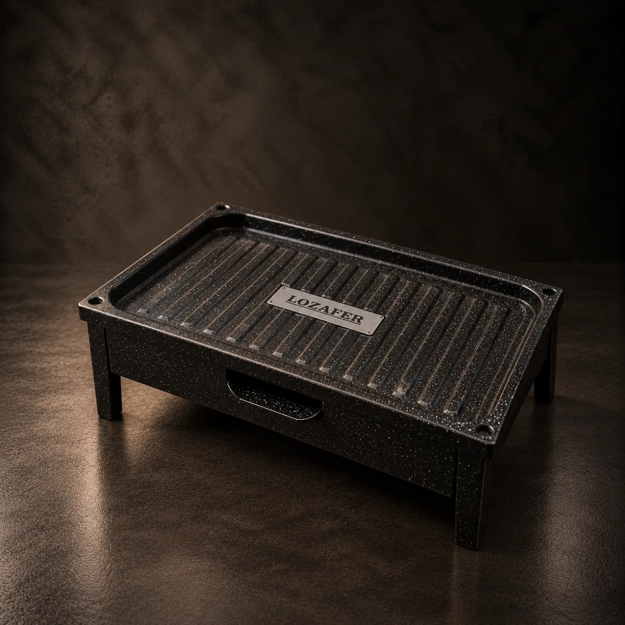 The Lozafer micro grill in enamelled steel, on dark stone