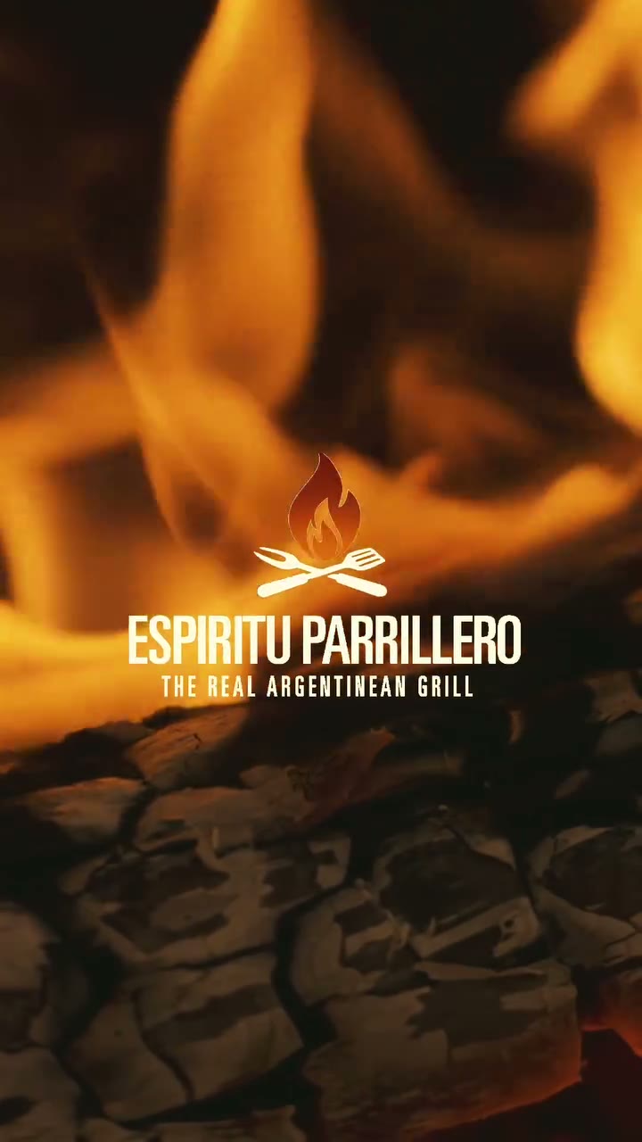 El isotipo y el logotipo de Espíritu Parrillero sobre una llama viva y un lecho de brasas, el último cuadro del film de la empresa